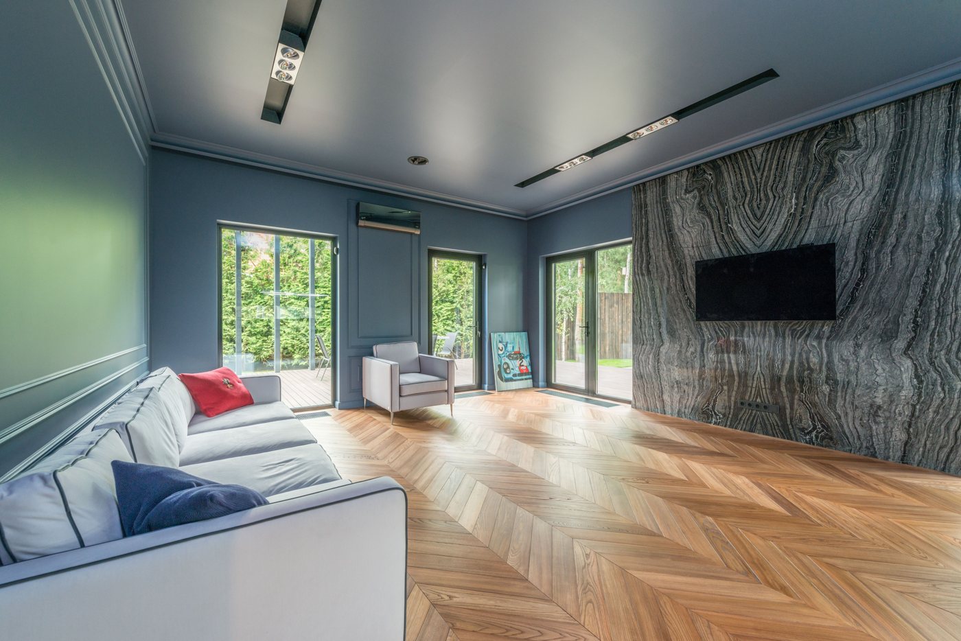 Blue-gray living room with painted walls, white trim and wood flooring